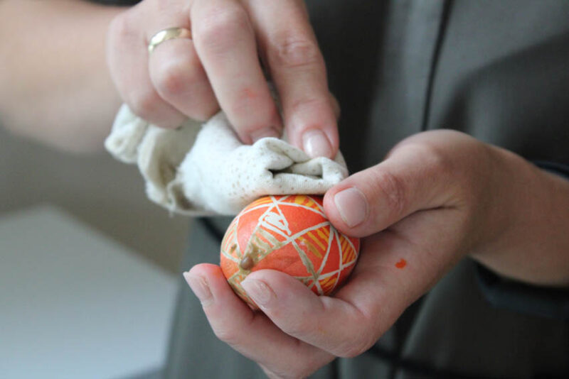 Ścieranie wosku za pomocą rozgrzanej ściereczki z powierzchni jajka
