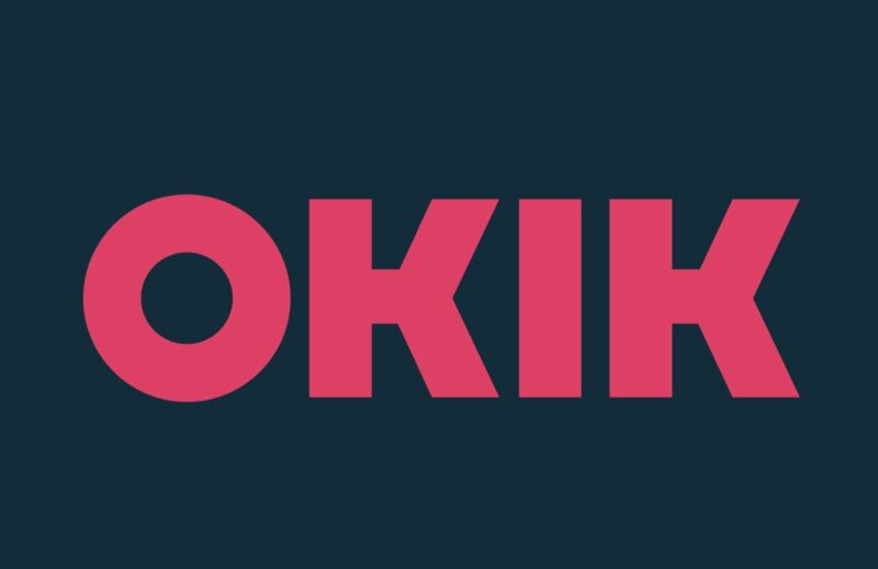 Grafika promująca OKIK. Prostokąt. Wyśrodkowany skrót OKIK zapisany wielkimi literami w kolorze różowym, na granatowym tle.